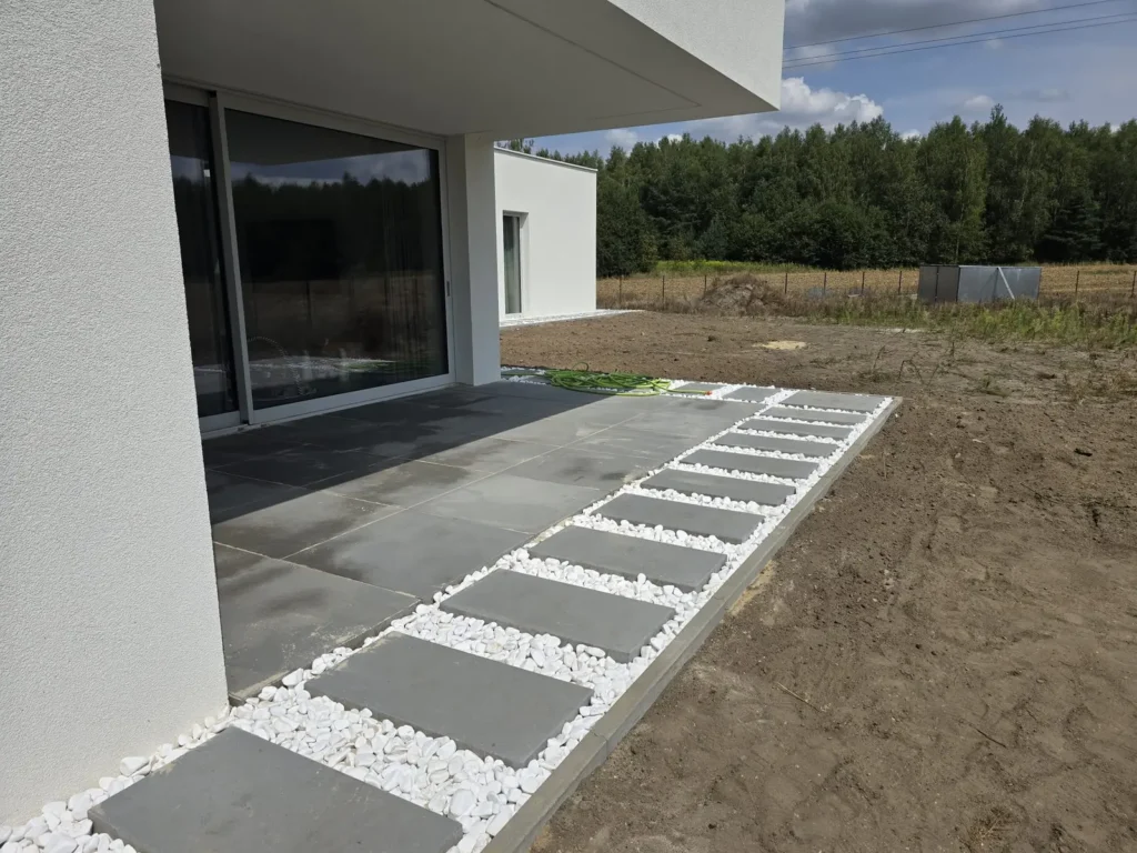 Taras przed budynkiem usługowym w odcieniach beżu